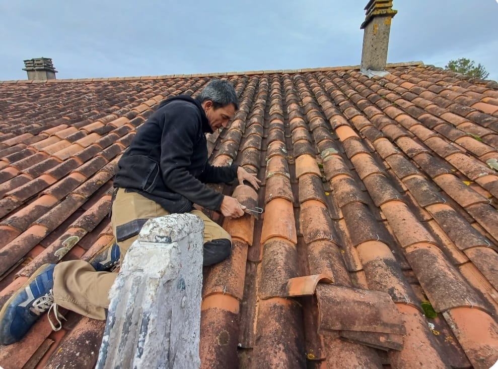 Artisan couvreur au travail sur un toit en tuiles